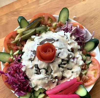 Beef gyro with garlic sauce, pickles, red cabbage and a tomato rose
